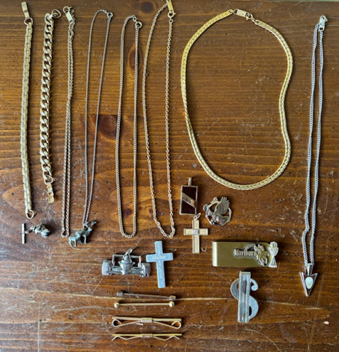 Collection of vintage high school jewelry spread across a wooden nightstand